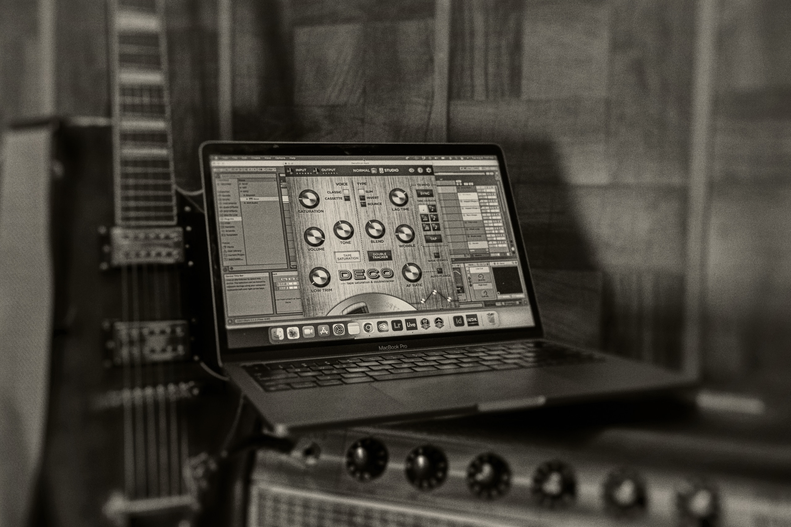 Black and white photo of laptop on top of a guitar amp with a DAW window open displaying the Deco plugin.