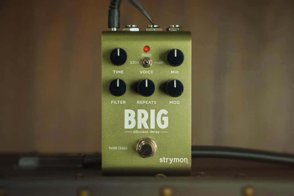 Brig on top of amp against wood background.