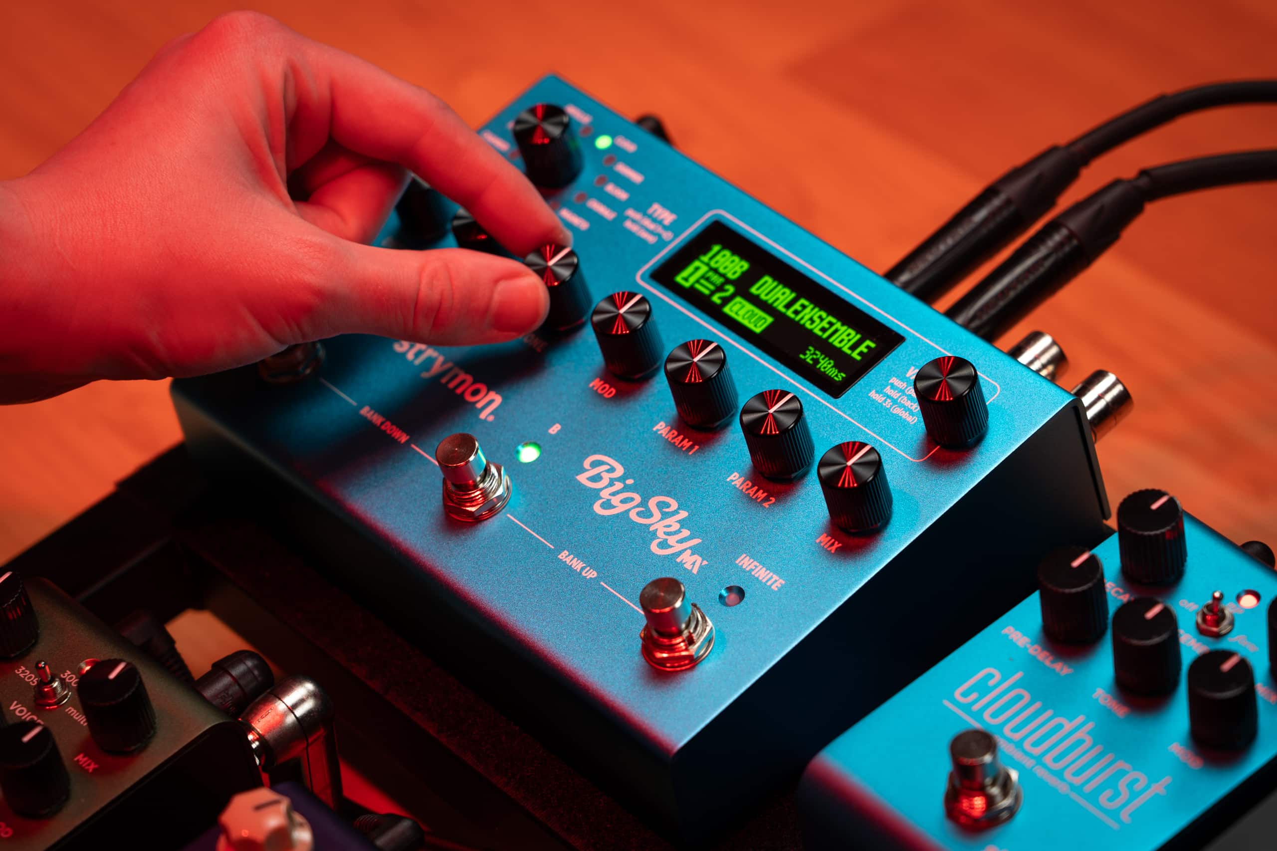 BigSky MX being used on stage. A hand is reaching over and grabbing one of its knobs.