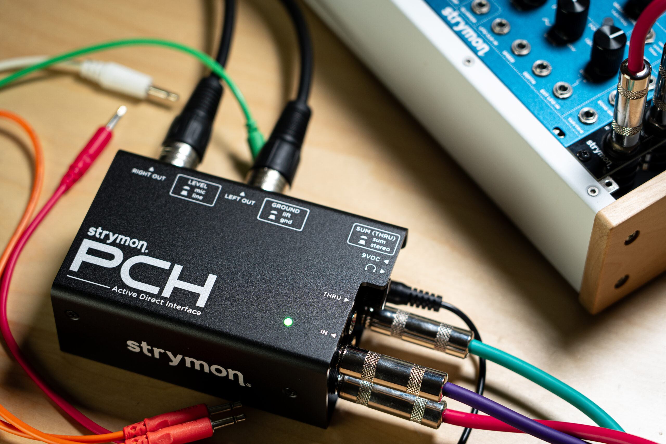 Strymon PCH resting near a Eurorack module case.