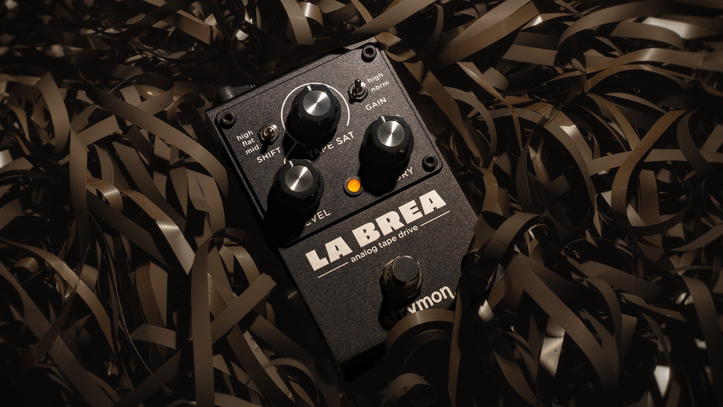 Strymon La Brea pedal sitting on a pile of magnetic tape.